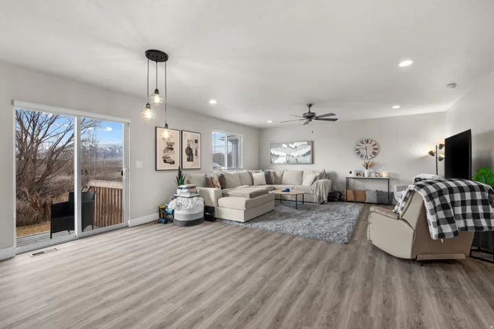 Spacious living area featuring wood-finish flooring, recessed lighting, and a ceiling fan
