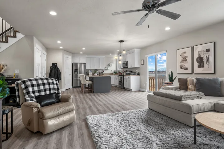 Open-concept living area featuring wood-finish flooring, a contemporary ceiling fan, and recessed lighting