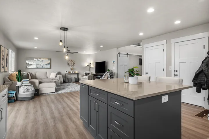 Kitchen island with a light-toned countertop and dark gray cabinetry