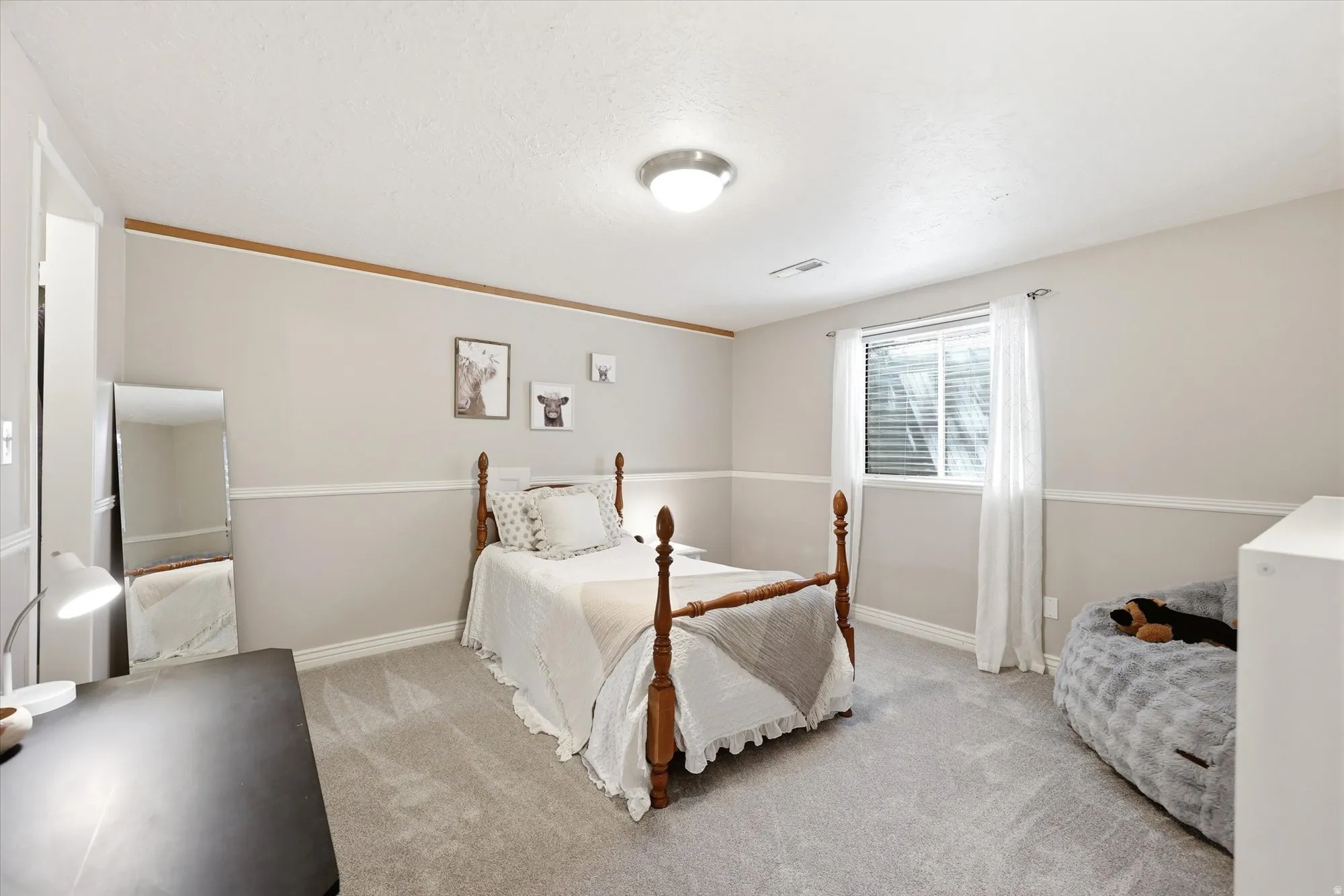 Carpeted room with a single window, white trim, and a chair rail molding