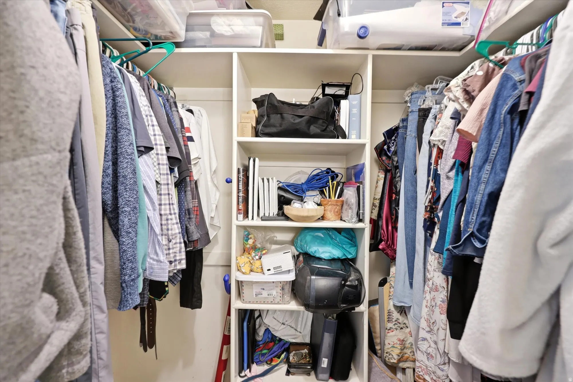 Custom closet system featuring built-in shelving and multiple hanging rods for ample storage
