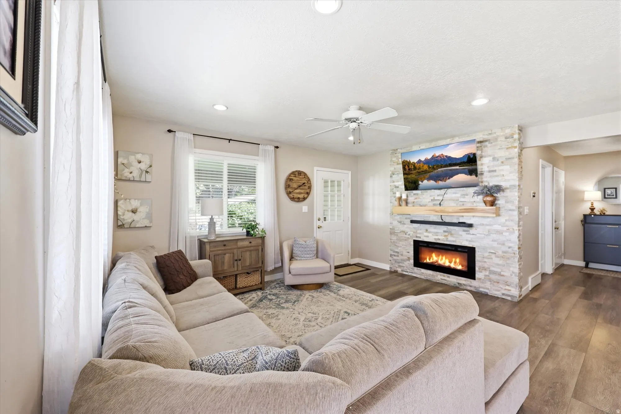 Living area featuring wood-finish flooring, a contemporary ceiling fan, and recessed lighting