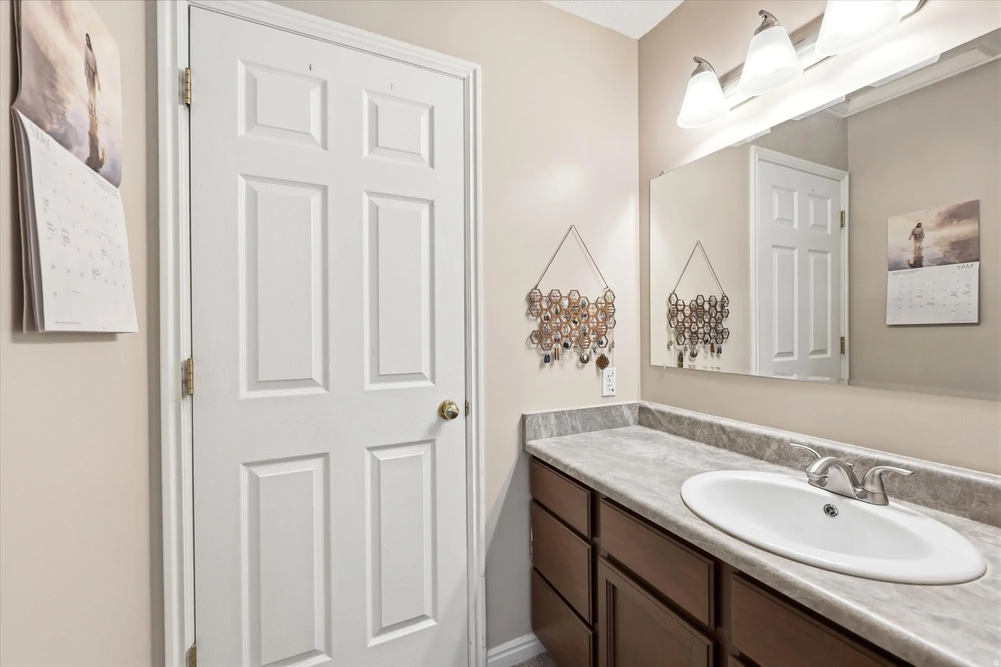 Bathroom vanity featuring an integrated oval sink, chrome faucet, and ample under-sink storage
