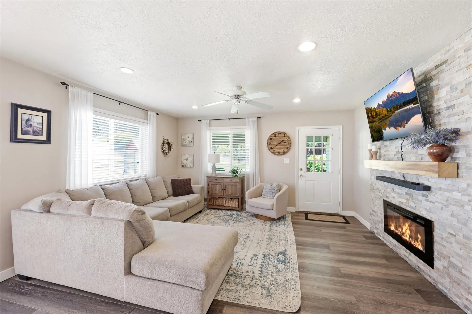 Living area featuring wood-finish flooring and a ceiling fan