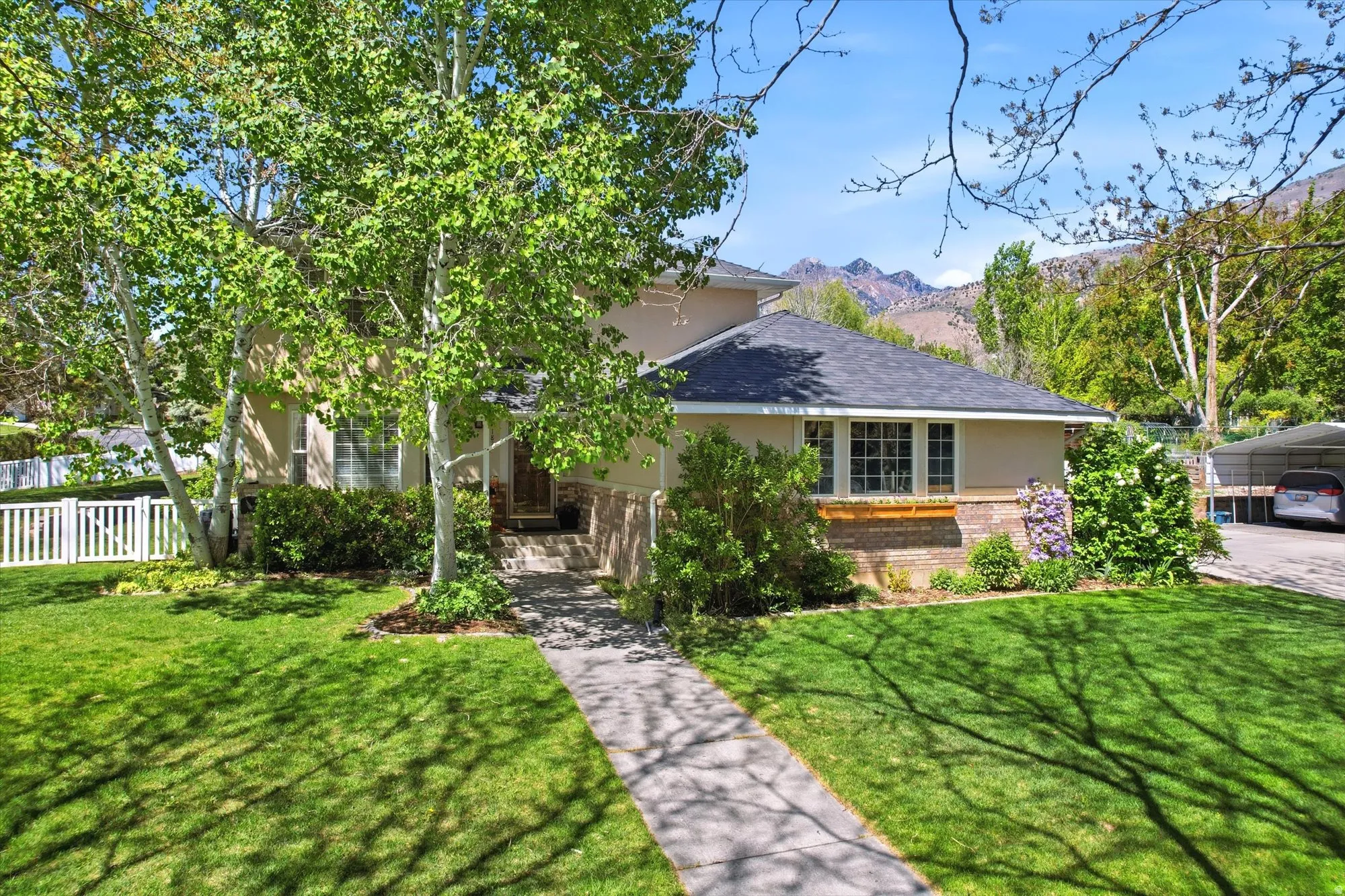 Light-toned exterior with a dark shingle roof and brick accents