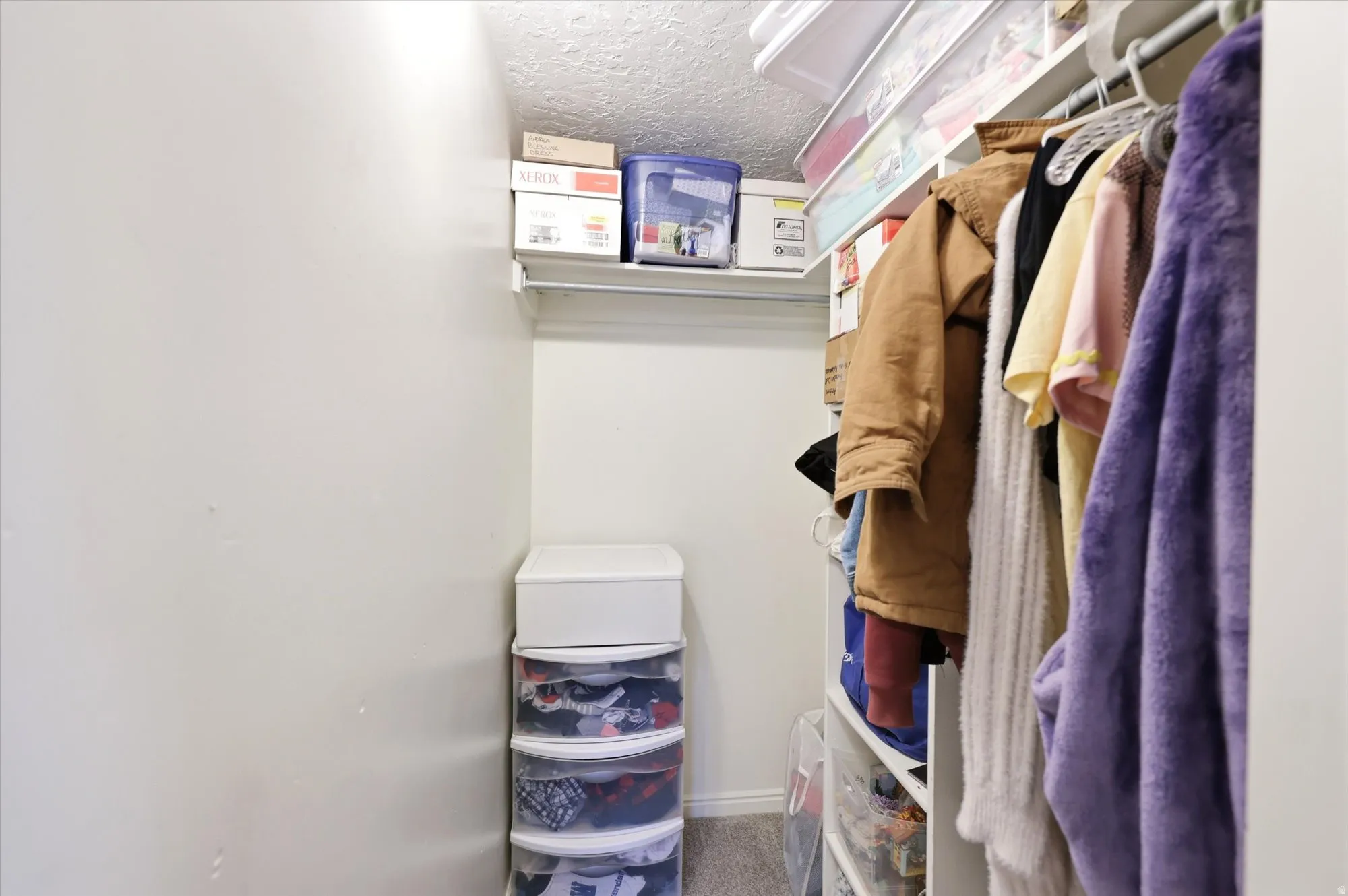 Closet featuring white walls, overhead shelving, and a clothing rod