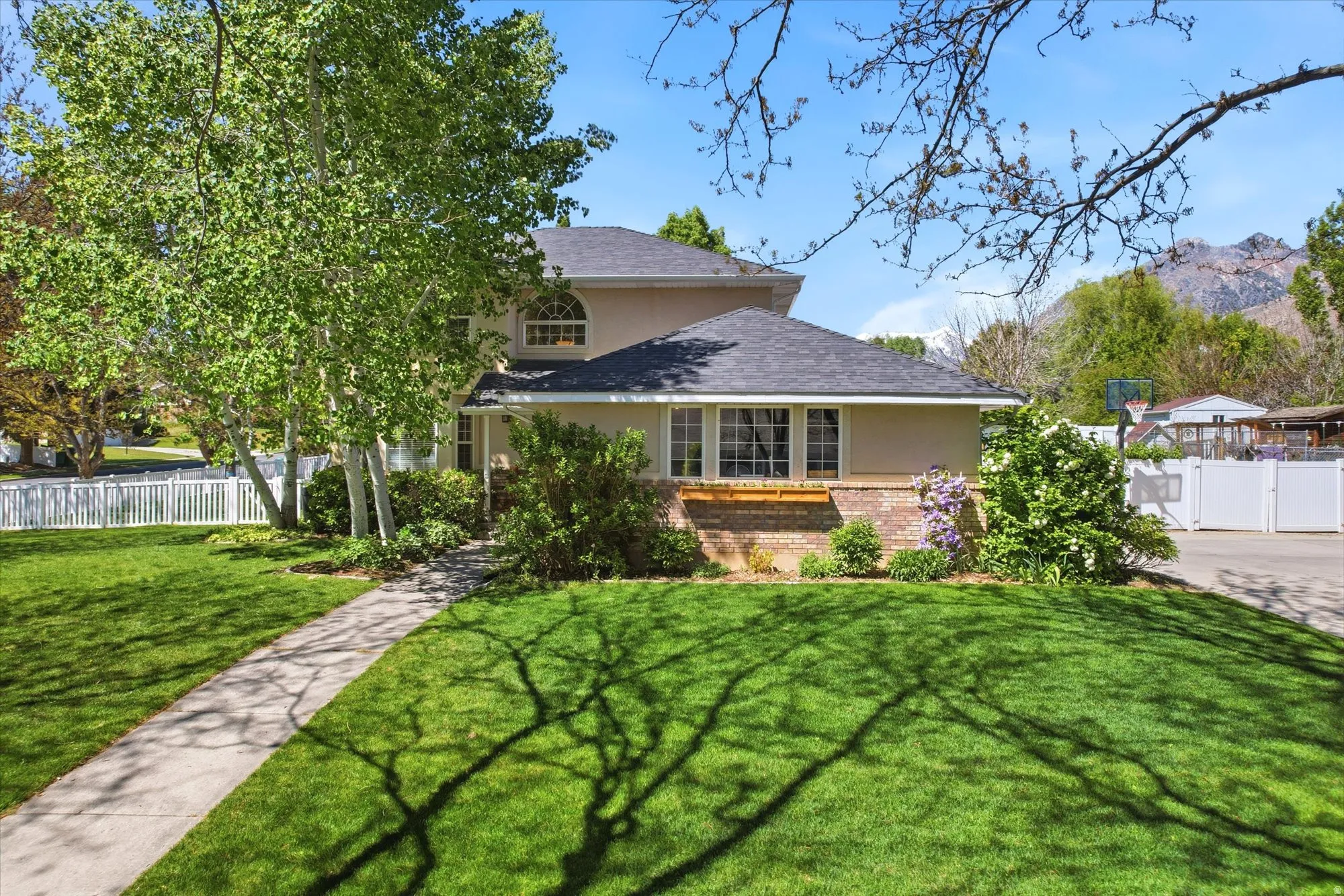 Front exterior showcasing a manicured lawn, established landscaping, and a concrete pathway