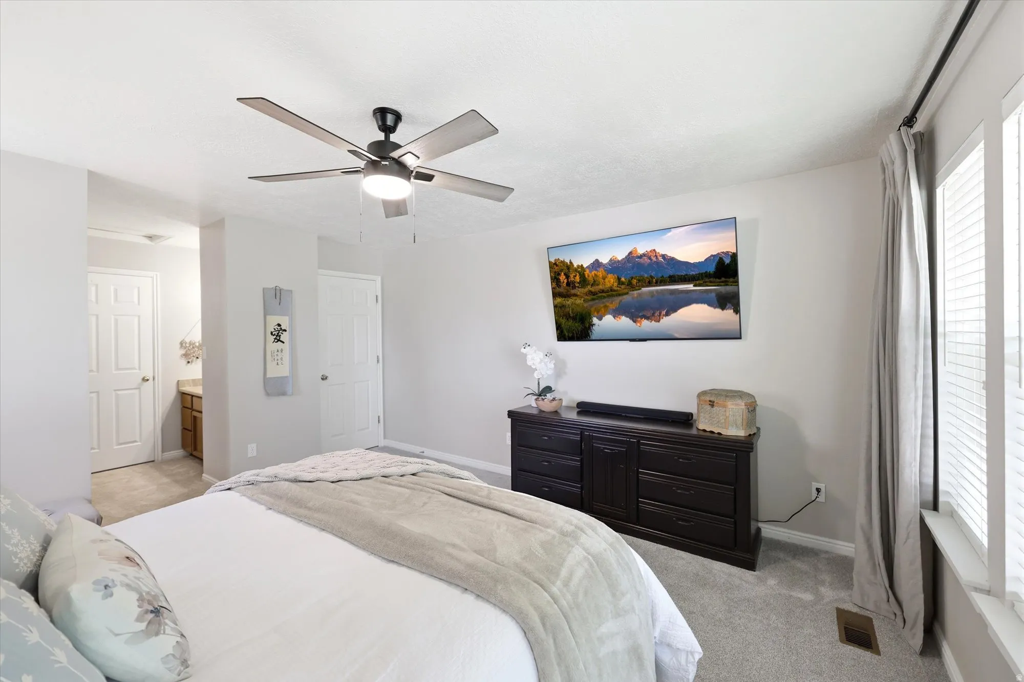 Spacious room featuring light gray wall paint and gray carpet flooring