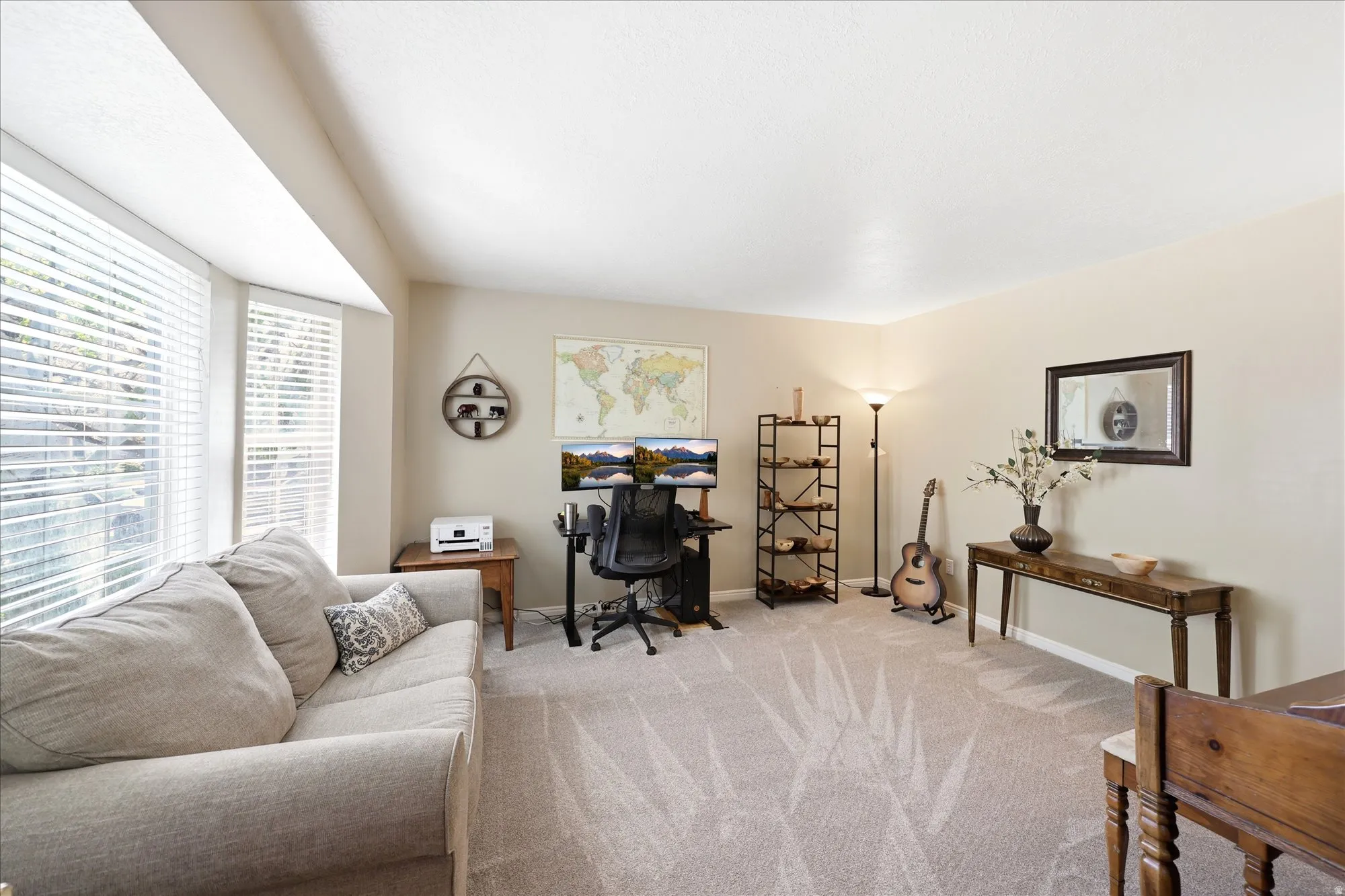Spacious room featuring neutral carpeting, light-toned walls, a large bay window, and recessed lighting
