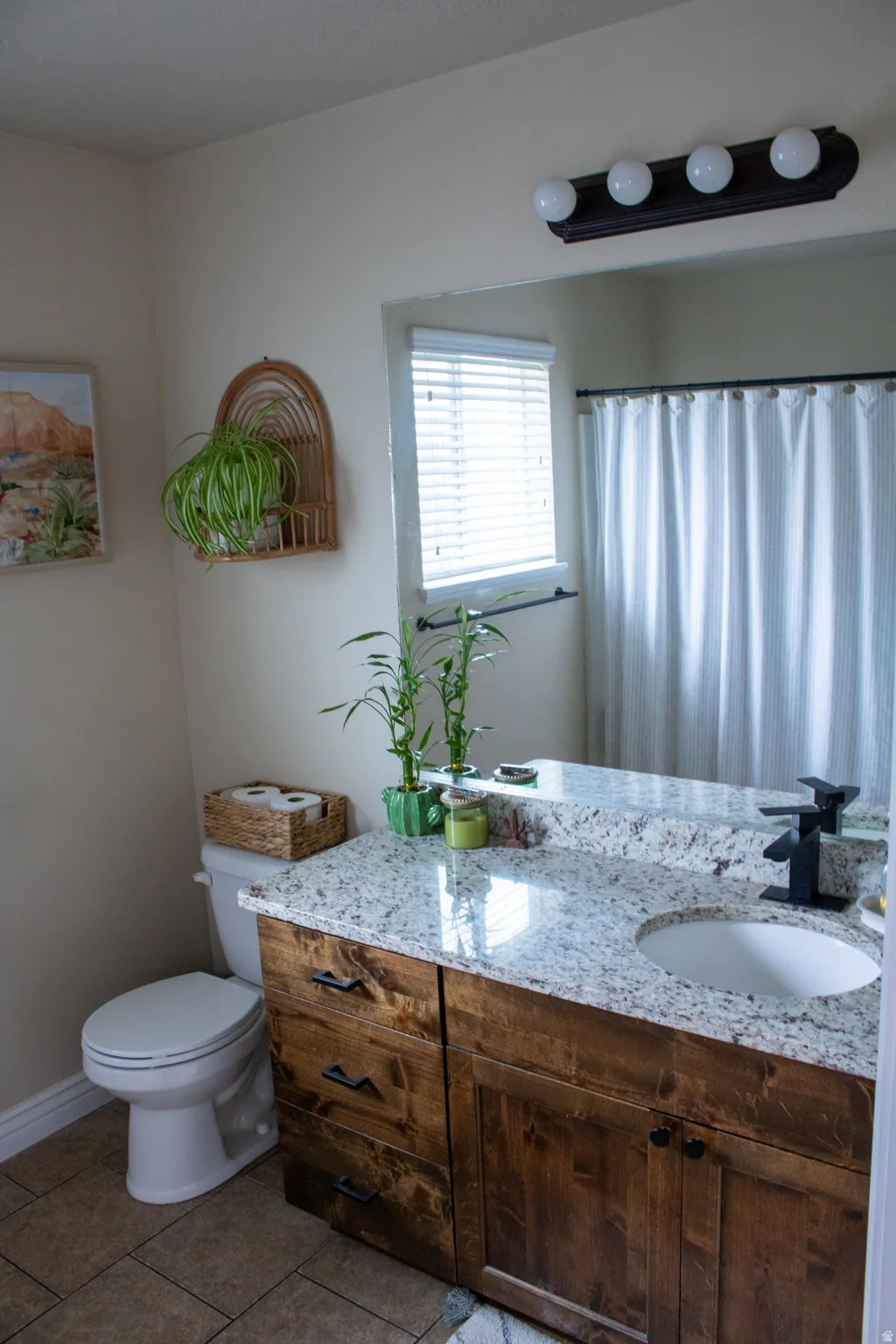Dual-sink vanity with a granite countertop, undermount sinks, and rustic wood-finish cabinetry