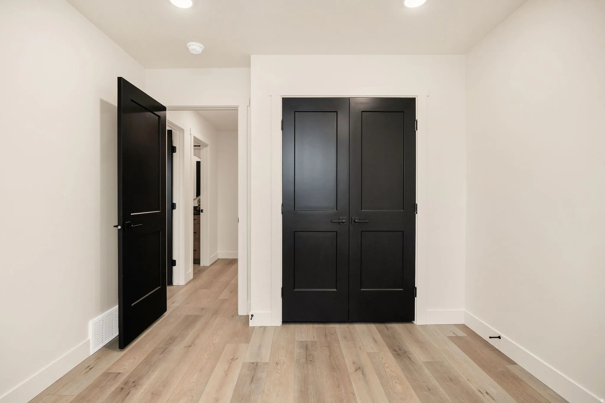 Light wood-finish flooring complemented by white baseboards