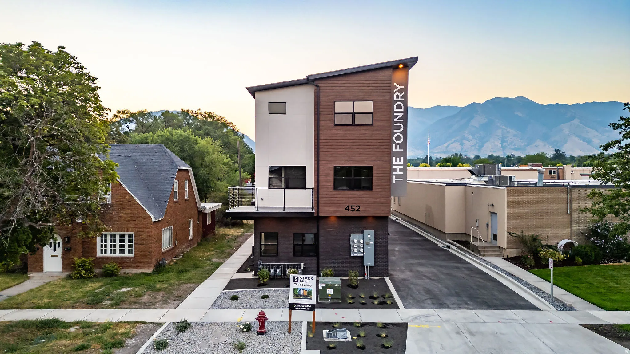 Modern facade featuring vertical wood-look siding and white stucco