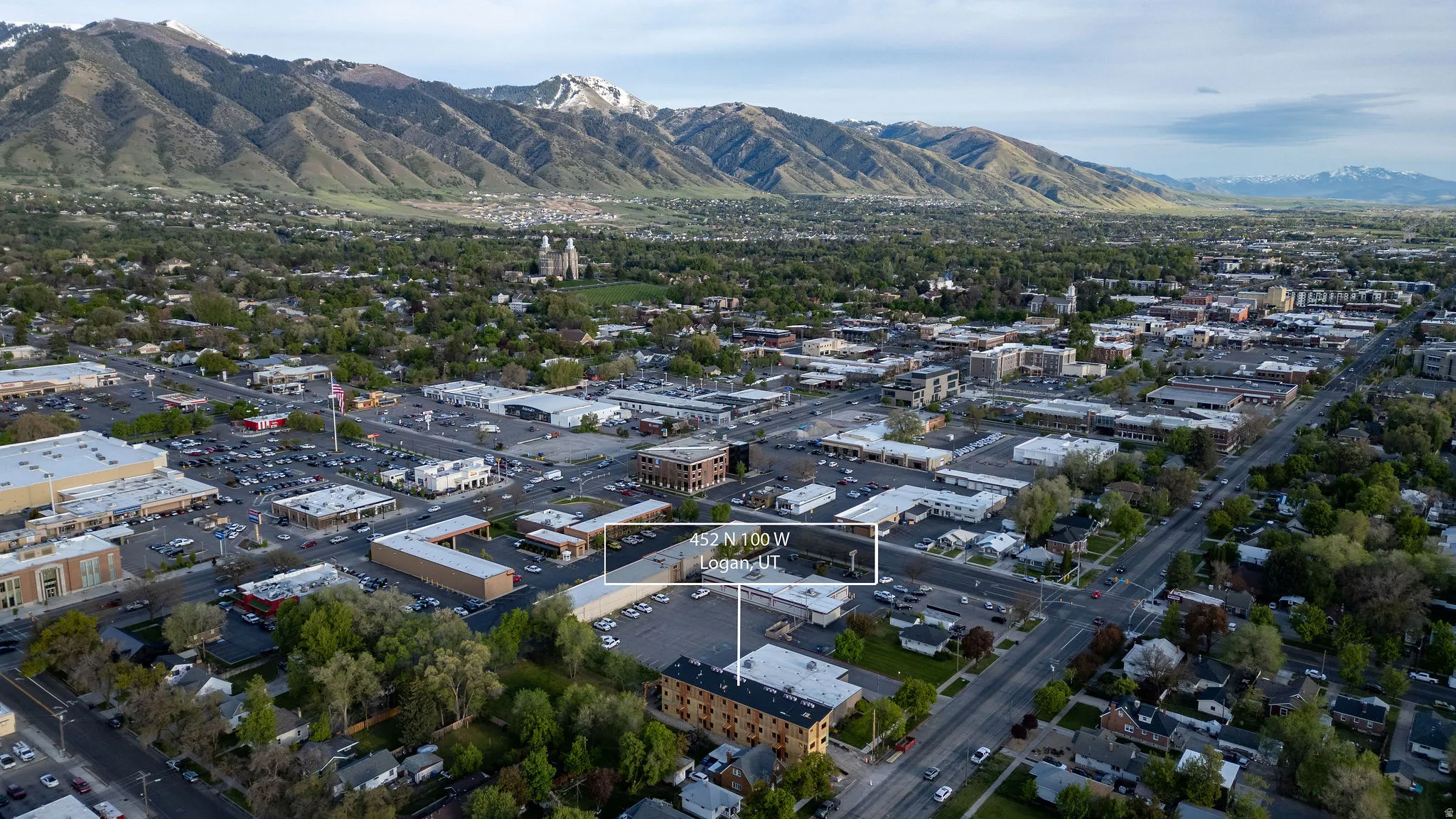 Aerial perspective showcasing a commercial district with a backdrop of snow-capped mountains