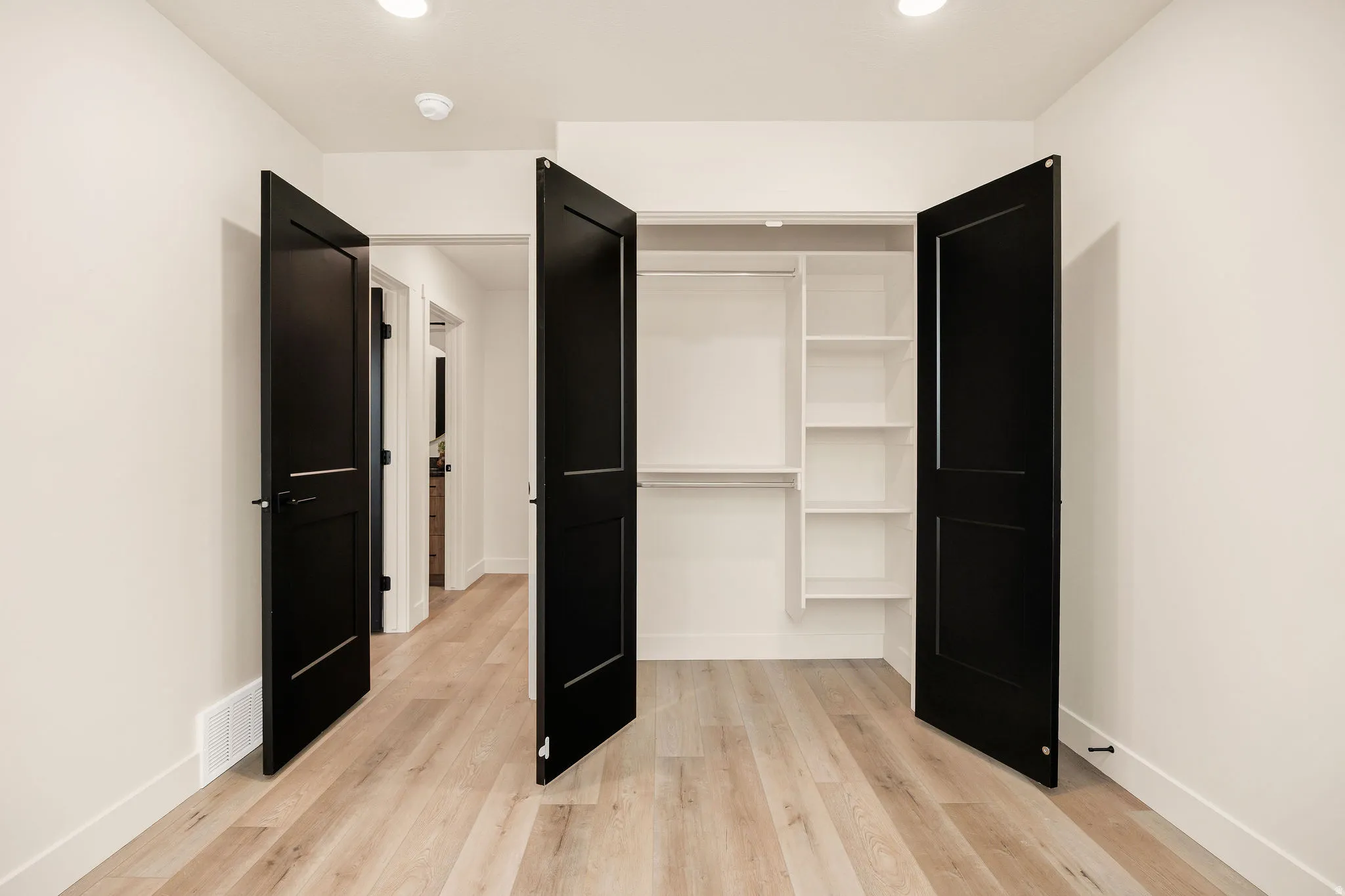 Recessed lighting illuminates the wood-finish flooring
