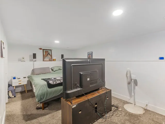 Carpeted room with white walls and recessed lighting