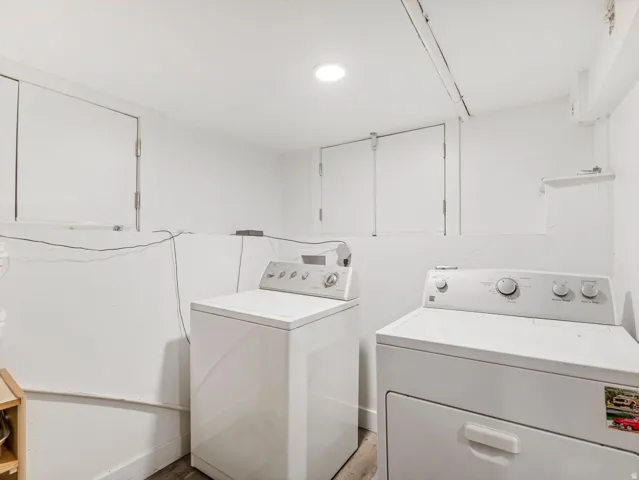 Dedicated laundry space featuring a white top-load washing machine and front-load dryer