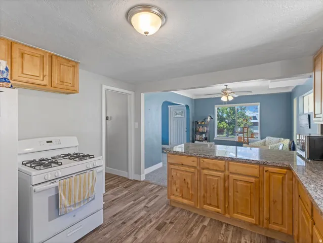 Kitchen featuring wood-finish flooring, natural wood cabinetry, and a light-toned countertop