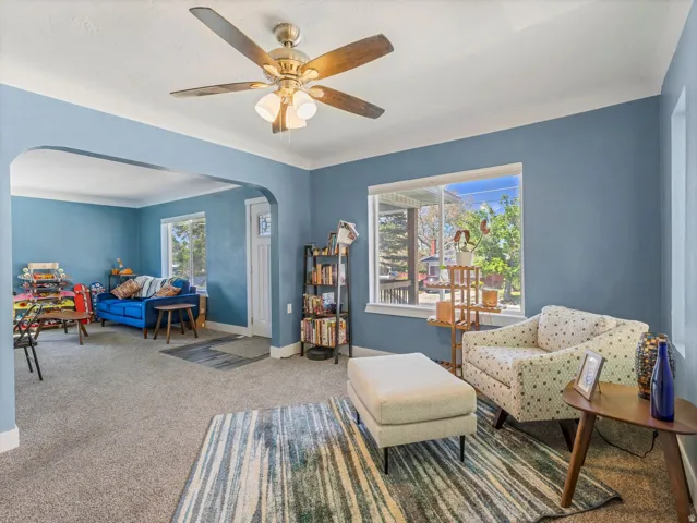 Carpeted living space featuring light blue walls and white trim