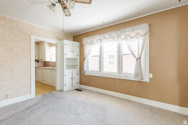 Bright interior space featuring a multi-pane window, built-in cabinetry, and a ceiling fan