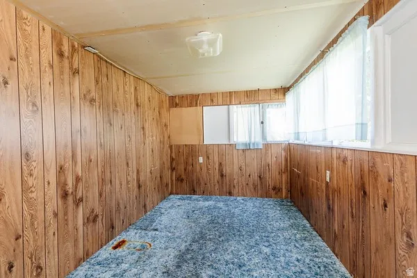 Room featuring wood-finish paneling walls and multiple windows
