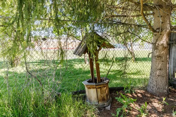 Fenced yard area featuring a decorative wooden wishing well