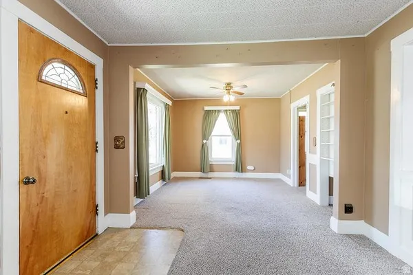 Entryway with wood-finish door featuring an arched decorative glass insert