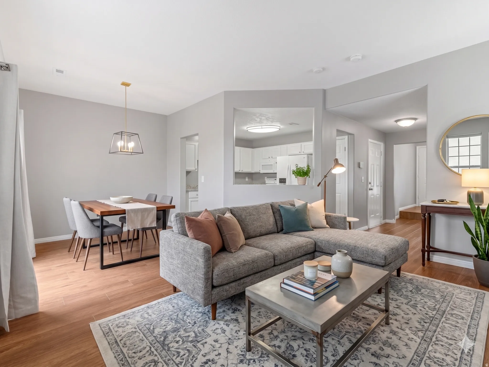Open-concept living area featuring wood-finish flooring, recessed lighting, and a dining space with a contemporary pendant light