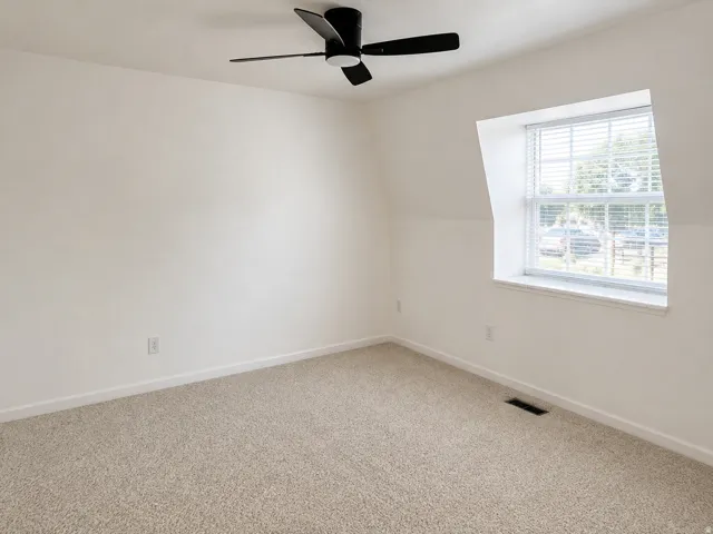 Window with blinds, ceiling fan with light, and neutral carpeting