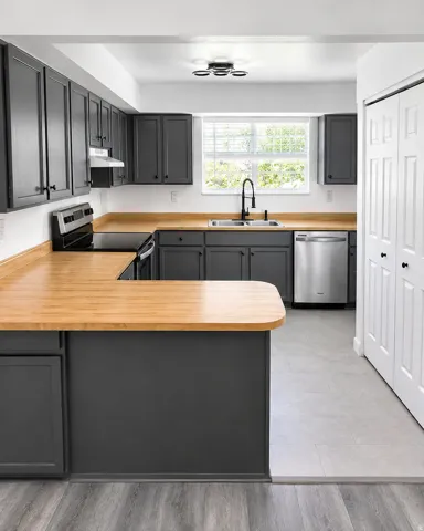 U-shaped kitchen featuring charcoal cabinetry, wood-finish countertops, stainless steel appliances, a black pull-down faucet, and a modern ceiling light fixture