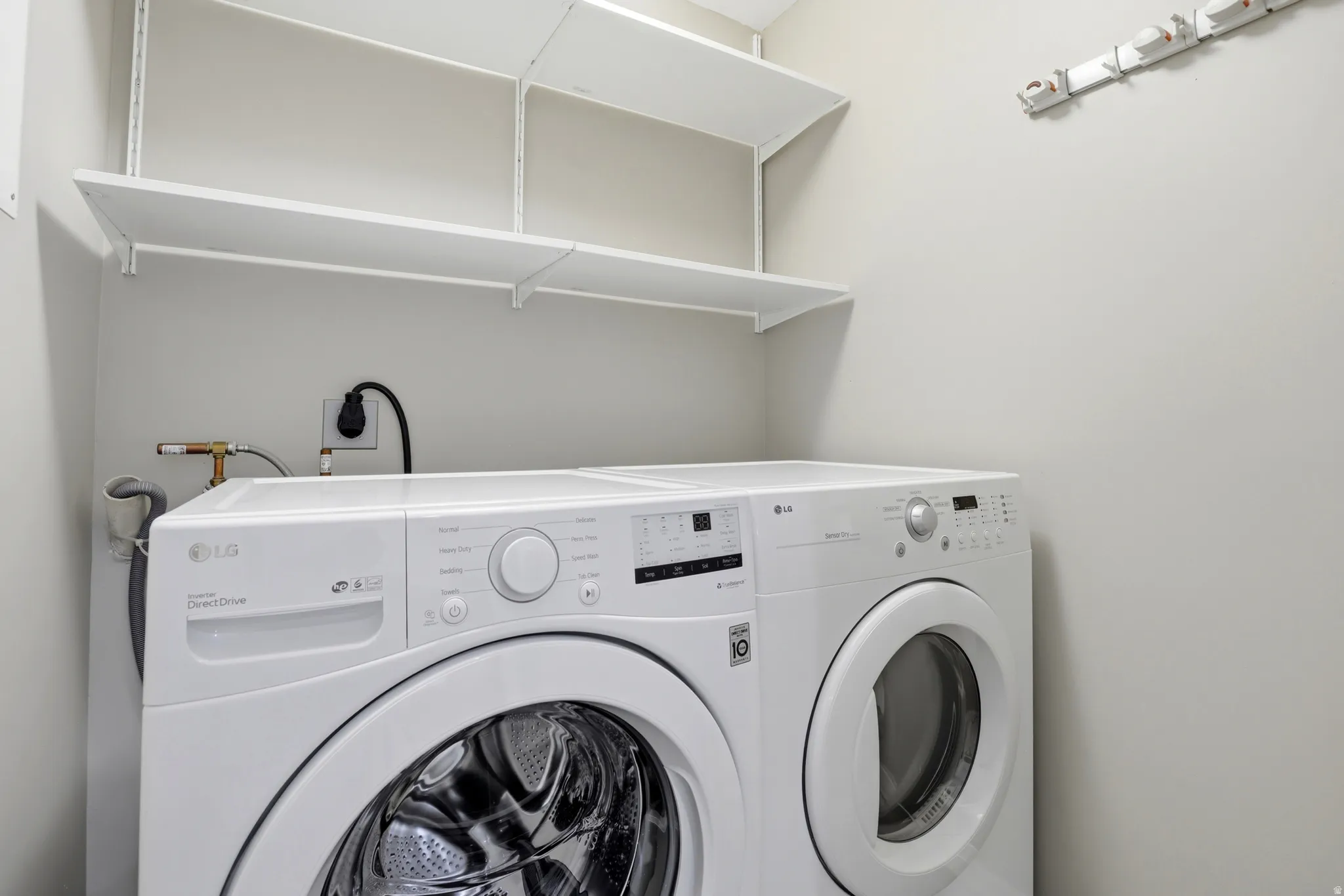 Dedicated laundry area with white stacked shelving
