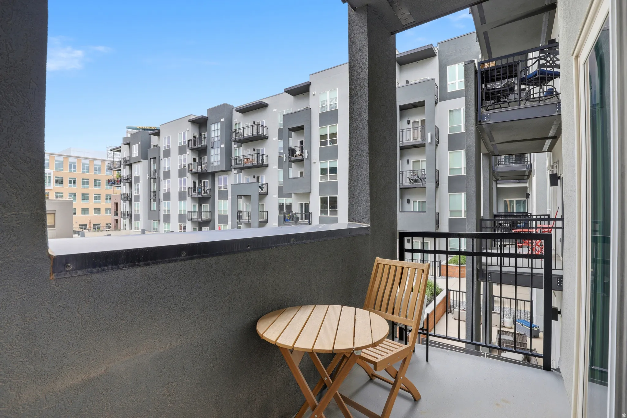 Private balcony space featuring a smooth concrete floor and black metal railing