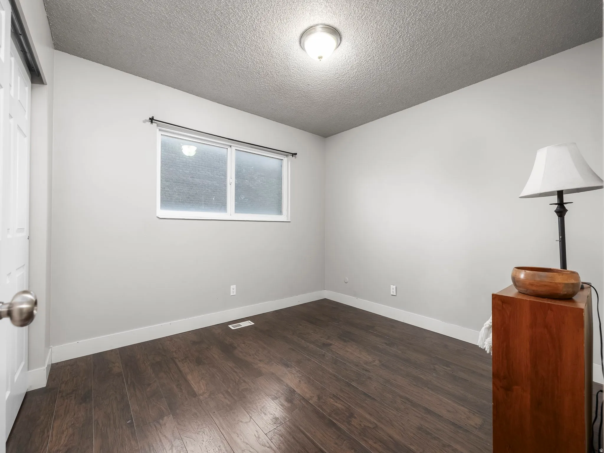 Bedroom featuring wood-finish flooring, white baseboards, and neutral wall paint