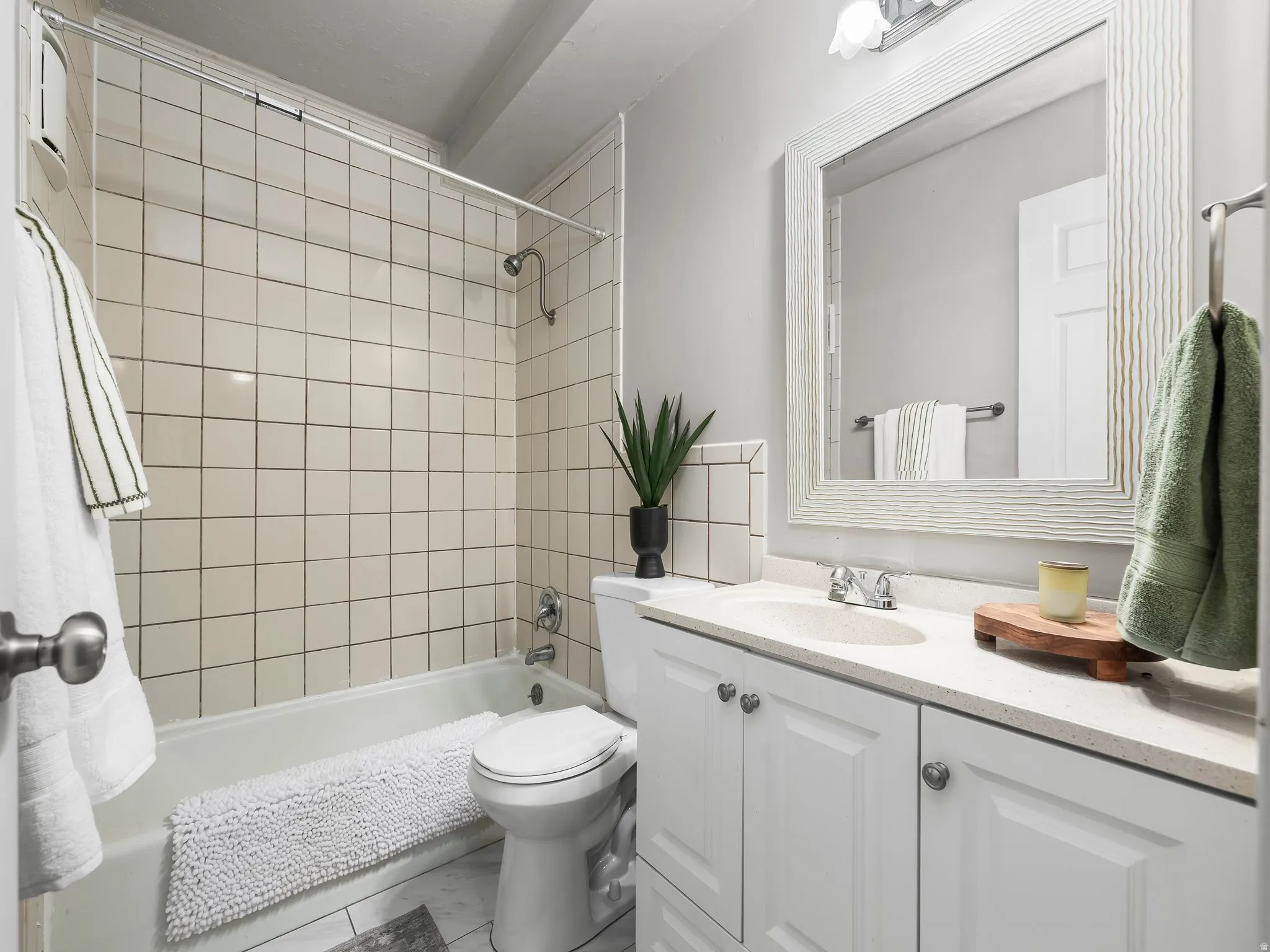 Bathroom featuring a full vanity with an integrated sink, white cabinetry, and a light-toned countertop