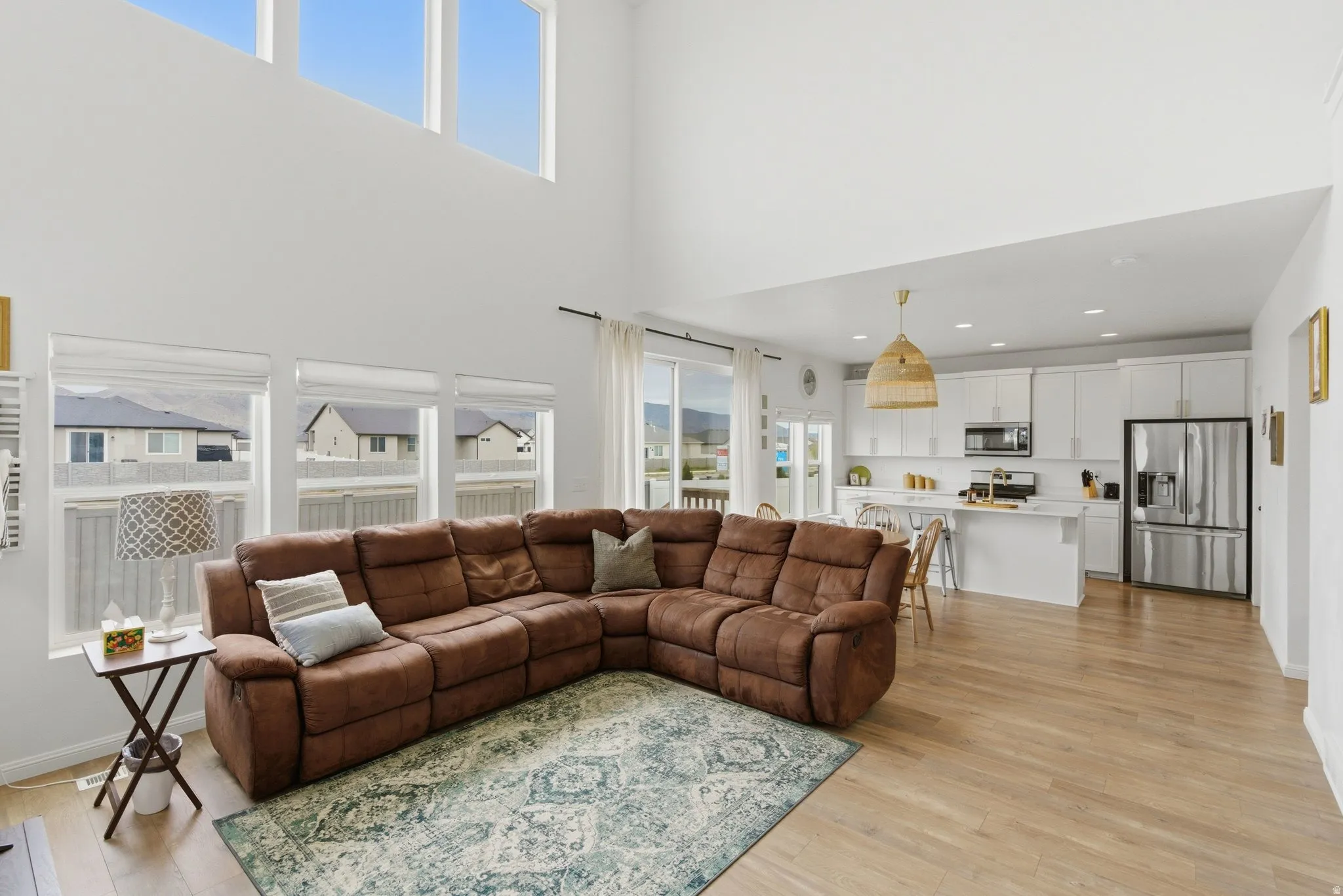 Open-concept living space featuring high ceilings and wood-finish flooring