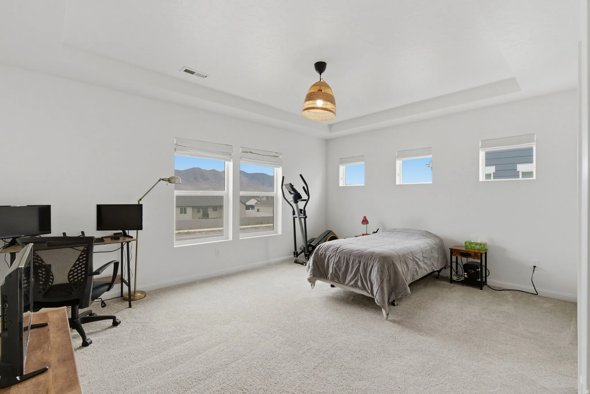 Spacious room featuring light-toned carpeting and a recessed ceiling design
