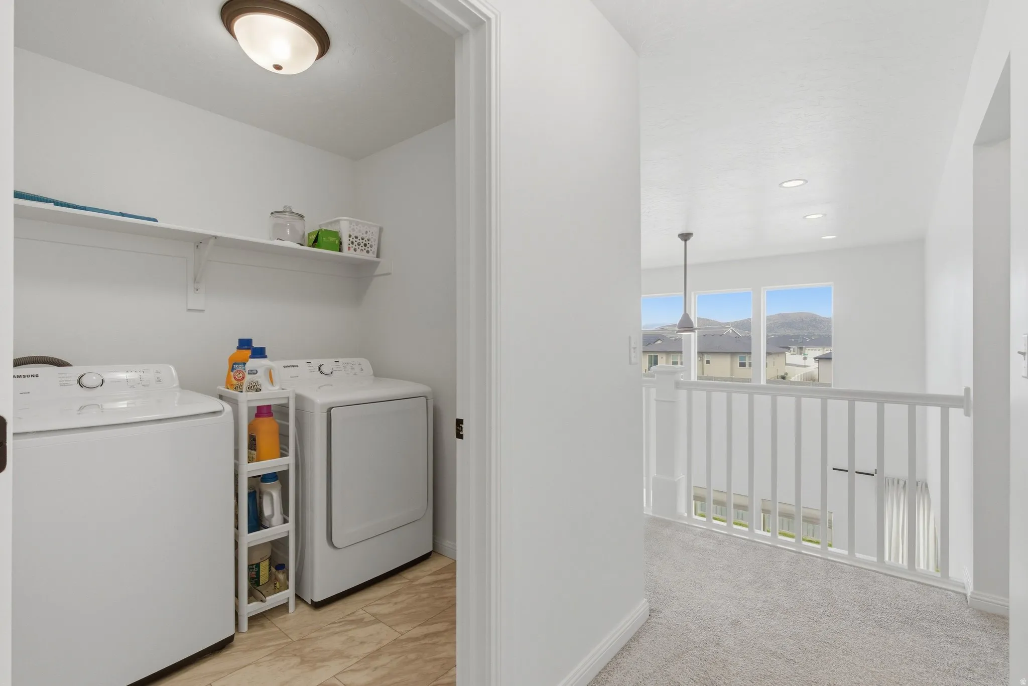 Dedicated laundry space featuring a white shelf and tiled flooring