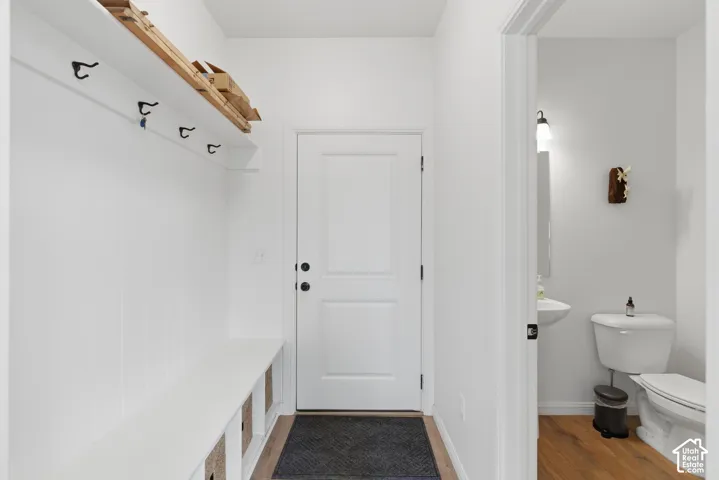 Entryway featuring built-in bench seating with storage, coat hooks, and a high shelf
