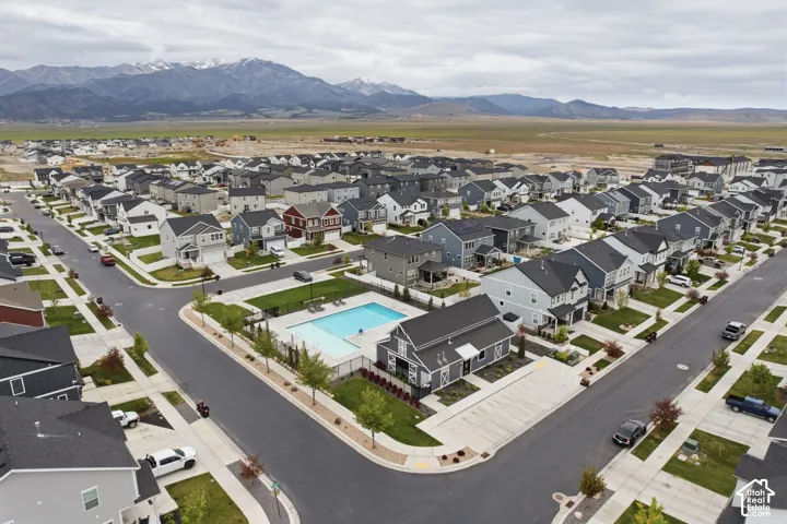 Community featuring a central swimming pool with surrounding fencing, paved streets, and a variety of detached homes
