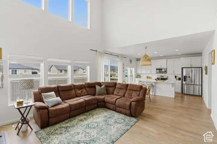 Open-concept living space featuring high ceilings and wood-finish flooring