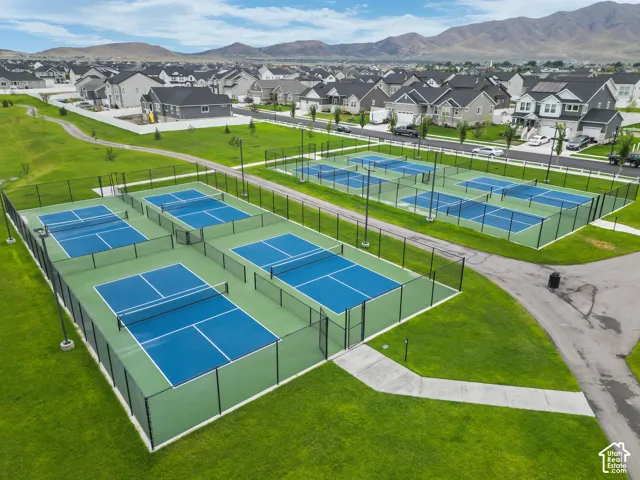 Six fenced pickleball courts with blue and green surfaces