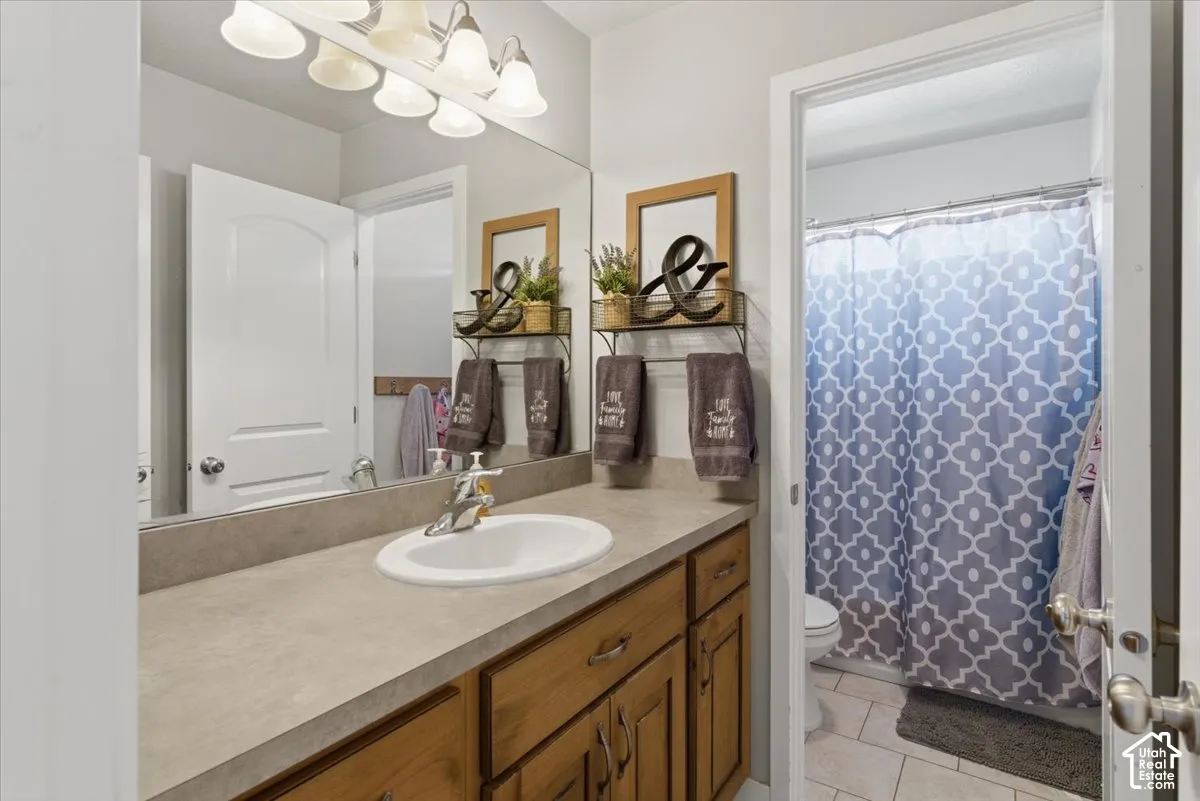 Bathroom vanity featuring a single-basin sink, chrome faucet, and expansive countertop