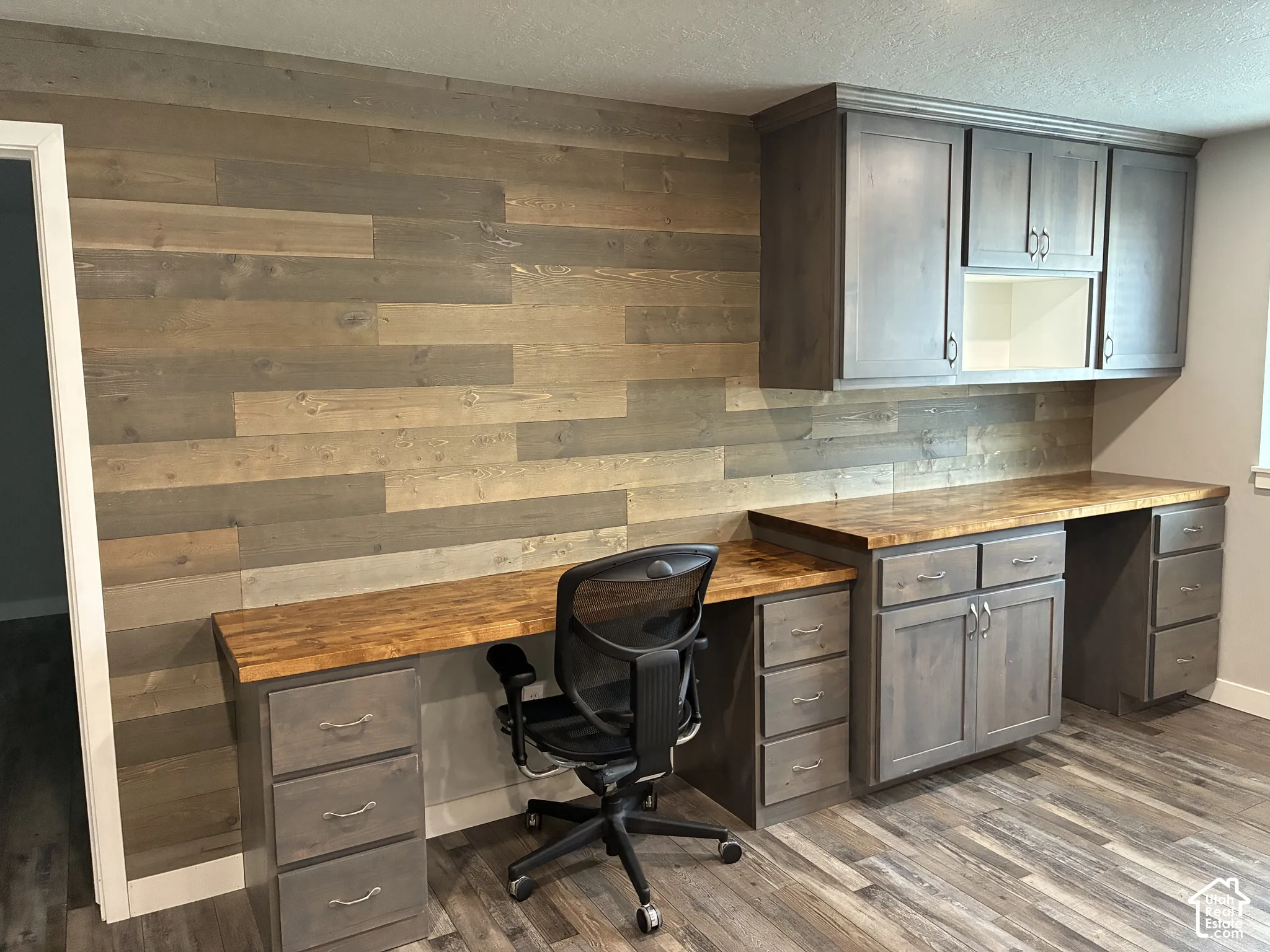 Wood plank accent wall with a built-in desk and cabinetry
