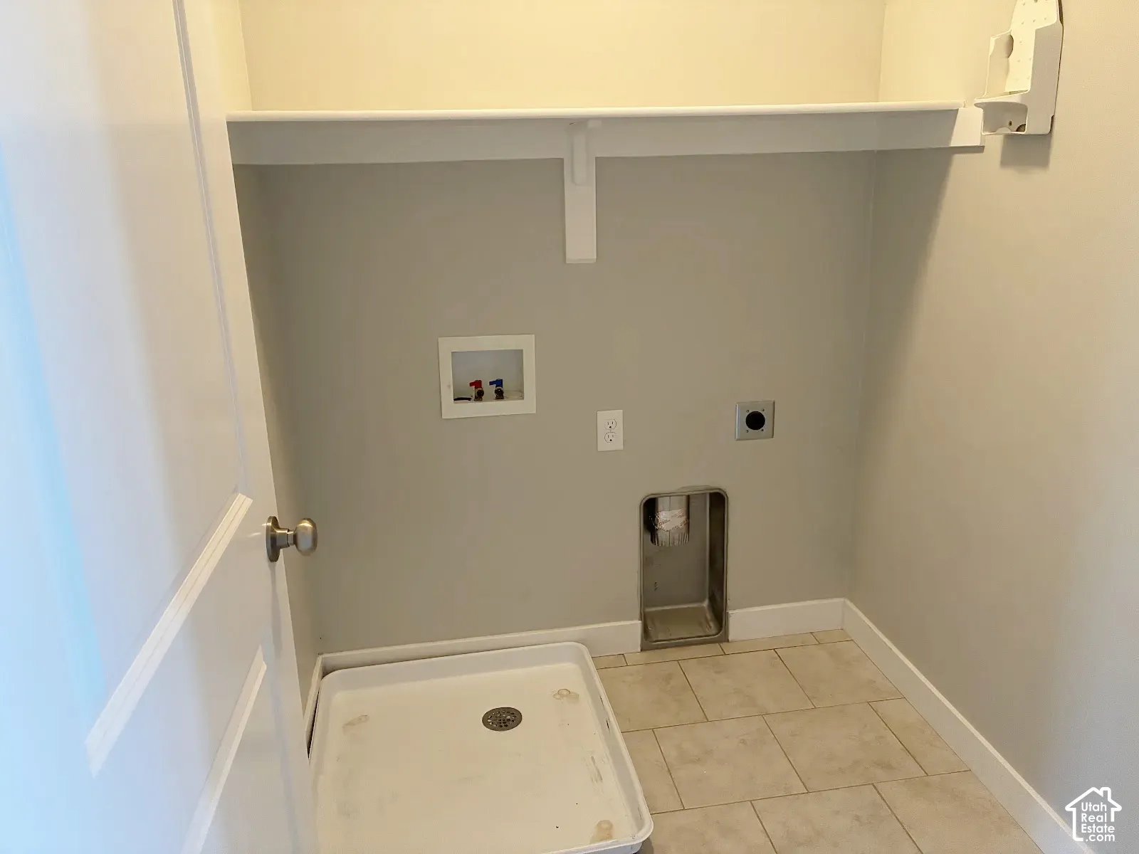 Laundry area featuring a built-in shelf, neutral wall color, and tile flooring