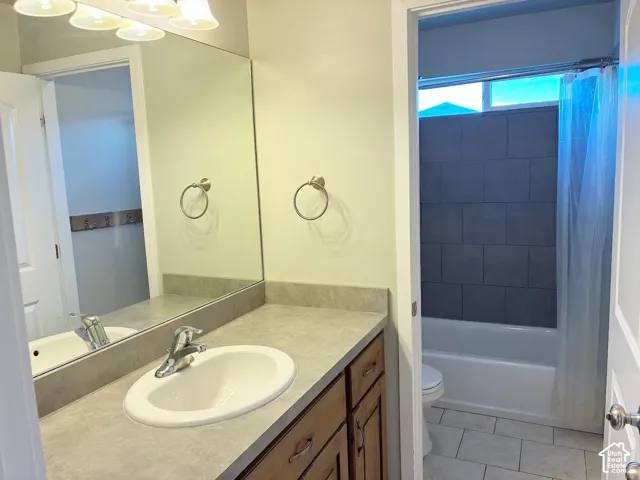 Vanity with an integrated sink and chrome faucet, full-width mirror, and overhead lighting