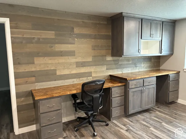 Wood plank accent wall with a built-in desk and cabinetry