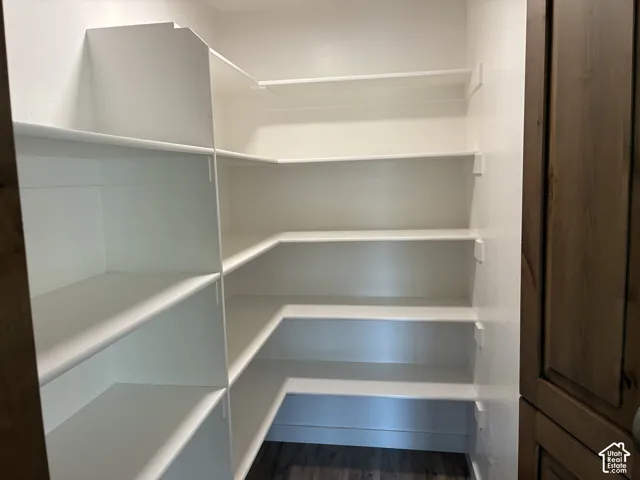Built-in shelving with multiple levels, white finishes, and wood-finish flooring