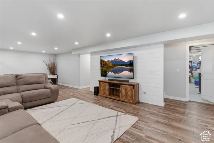 Spacious entertainment area featuring recessed lighting and wood-finish flooring