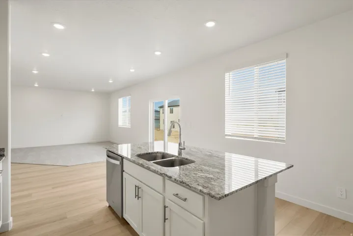 Kitchen island with granite countertop, double stainless steel sink, and gooseneck faucet