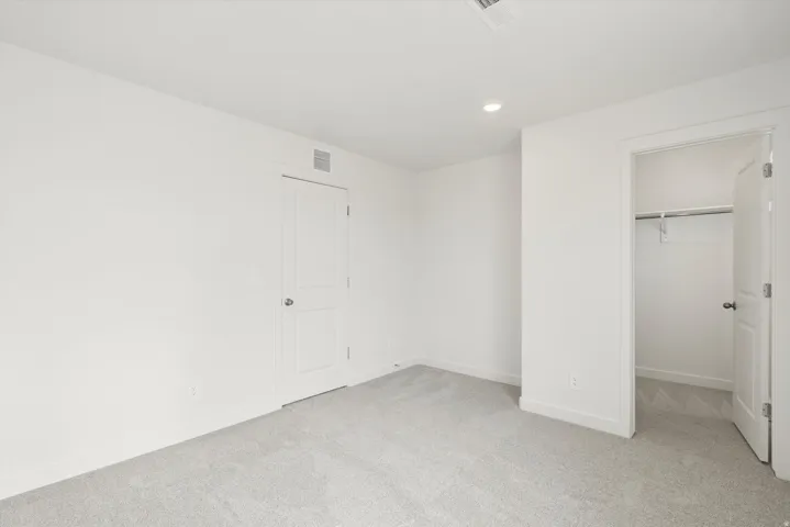 Light gray carpeting throughout the room and closet