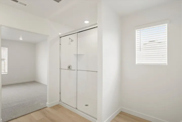 Modern shower enclosure featuring a sliding glass door and chrome fixtures